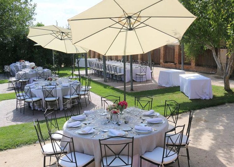 Mobiliario y sombrillas para evento en jardín