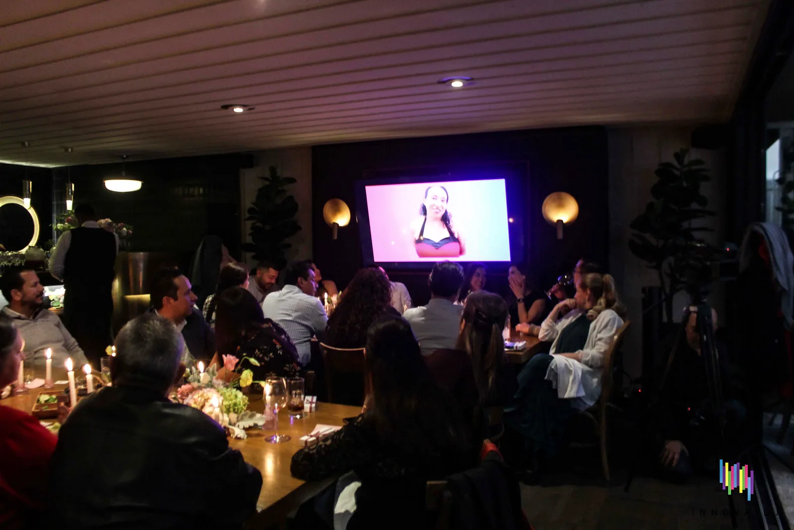 Invitados viendo una proyección en pantalla durante una celebración